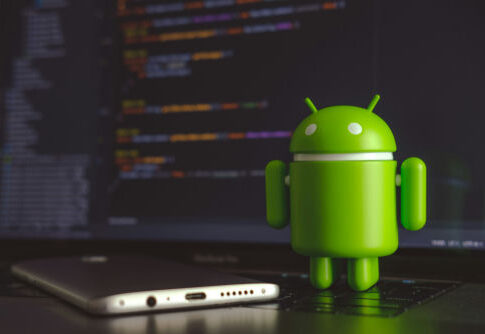 Android figurine in front of a laptop screen.