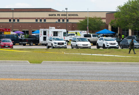 High school parking lot with emergency vehicles and tents
