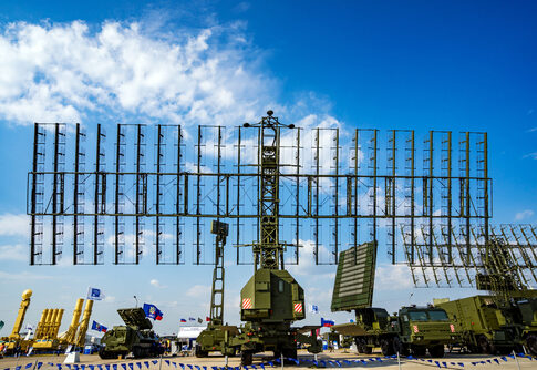Military radar system displayed at an outdoor exhibition under a blue sky