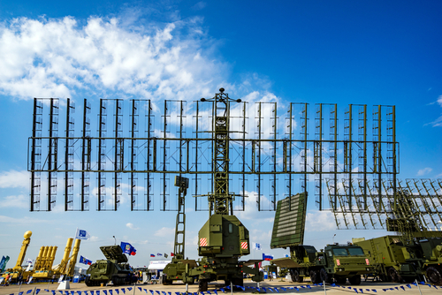 Military radar system displayed at an outdoor exhibition under a blue sky