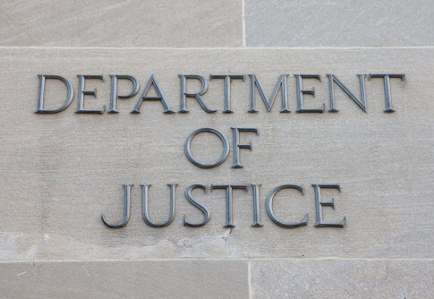 Sign reading Department of Justice on a stone wall